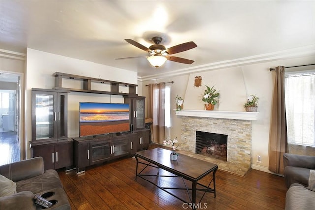 living room with wood-type flooring, a fireplace, a ceiling fan, and baseboards