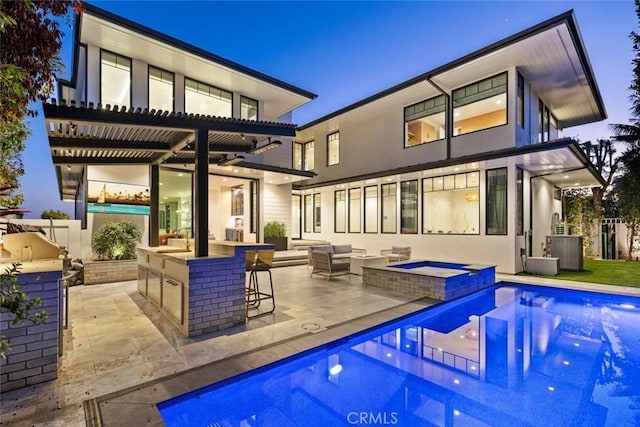 rear view of property with stucco siding, outdoor dry bar, a pergola, and area for grilling