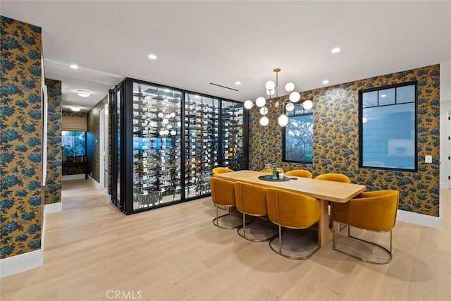 wine cellar featuring a notable chandelier, recessed lighting, light wood-style floors, baseboards, and wallpapered walls