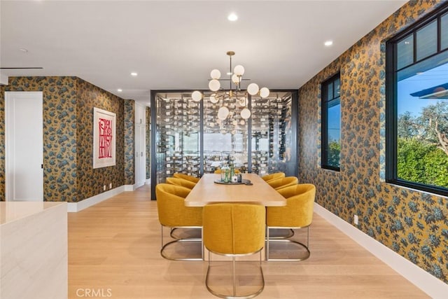 dining space featuring a chandelier, light wood-style flooring, baseboards, and wallpapered walls