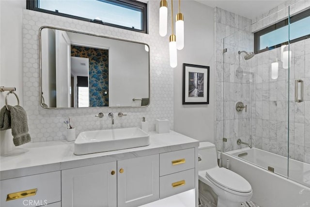 full bath featuring toilet, shower / bath combination with glass door, vanity, and decorative backsplash