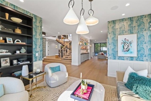 living area with light wood-style flooring, recessed lighting, stairway, and wallpapered walls