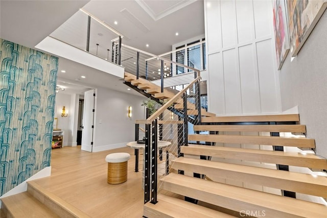 stairs featuring recessed lighting, baseboards, a high ceiling, and wood finished floors