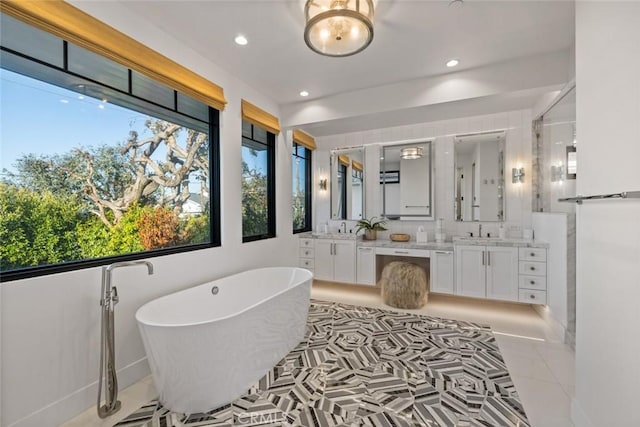 bathroom with a freestanding bath, tile patterned flooring, vanity, and recessed lighting