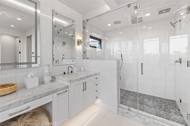 bathroom featuring visible vents, a stall shower, tile patterned flooring, and vanity