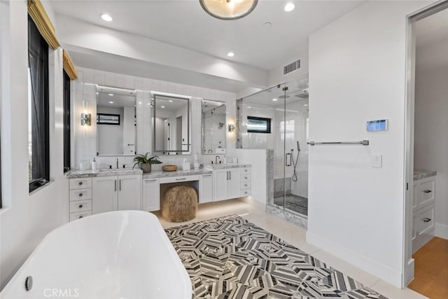 full bath featuring recessed lighting, vanity, visible vents, a freestanding bath, and a stall shower