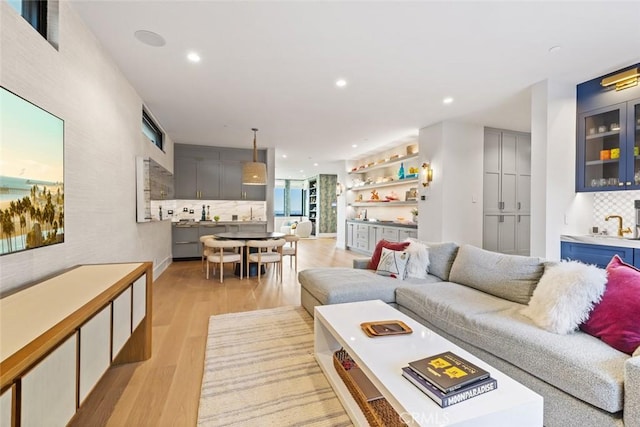 living area featuring indoor wet bar, light wood-style flooring, and recessed lighting