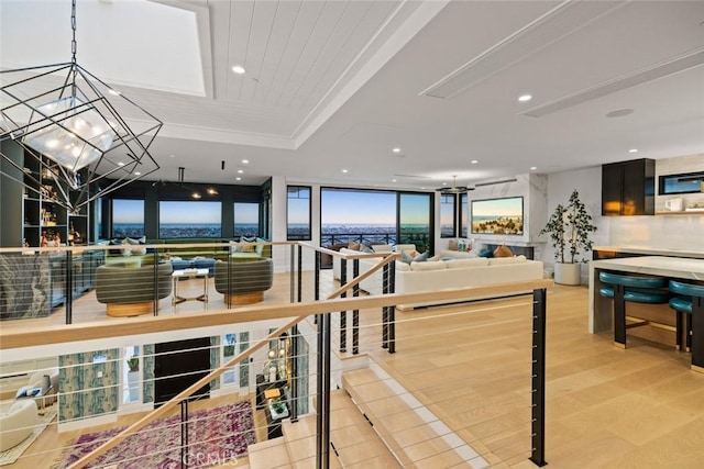 dining space featuring recessed lighting, a raised ceiling, expansive windows, a chandelier, and light wood-type flooring