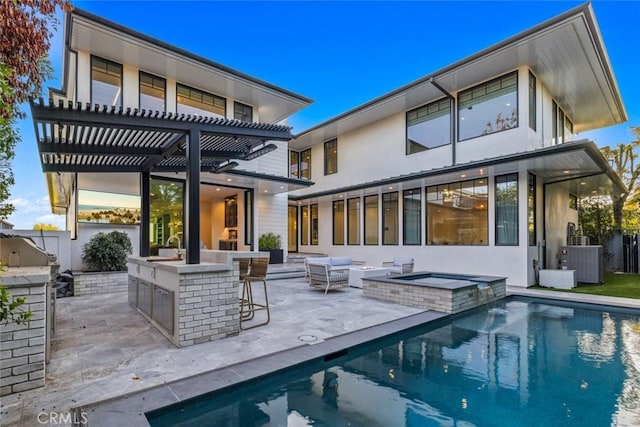 rear view of house featuring a patio, outdoor dry bar, an outdoor kitchen, and a pergola