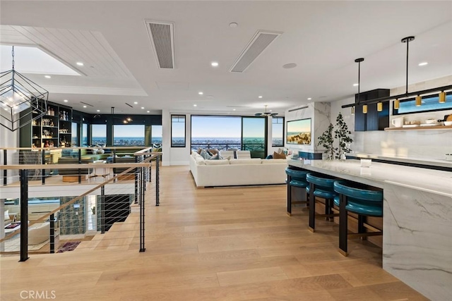 dining room featuring recessed lighting, visible vents, an inviting chandelier, light wood-style floors, and a wall of windows