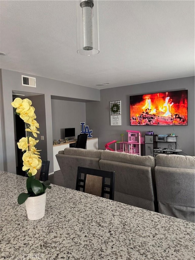 living area with visible vents and a textured ceiling