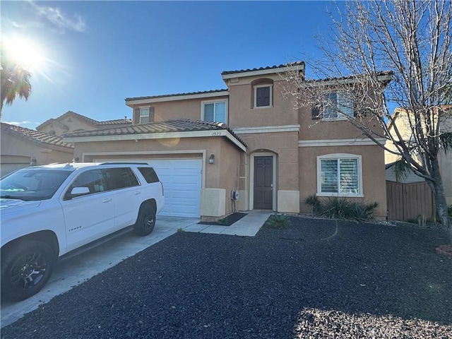 view of front of home featuring a garage, driveway, a tiled roof, and stucco siding