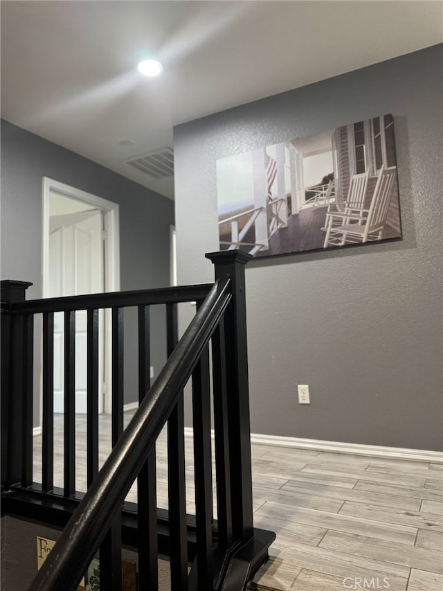 staircase featuring baseboards, wood finished floors, visible vents, and recessed lighting