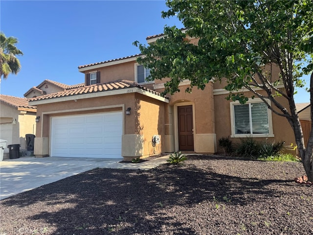 mediterranean / spanish-style house featuring a tile roof, an attached garage, driveway, and stucco siding