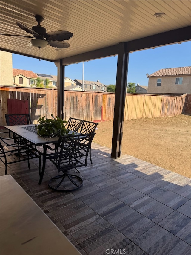 view of patio with ceiling fan, a fenced backyard, outdoor dining space, and a residential view