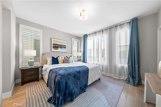 bedroom featuring light wood-type flooring and baseboards