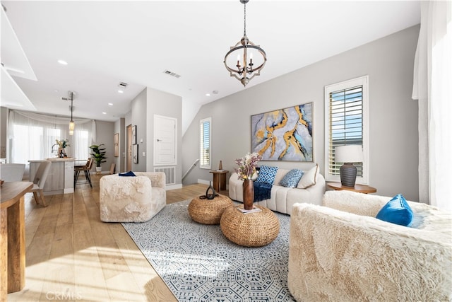 living room with a chandelier, light wood finished floors, visible vents, and recessed lighting