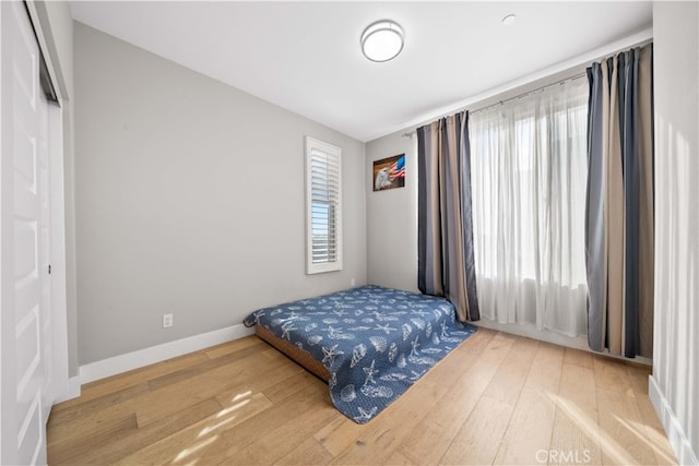 bedroom with baseboards and hardwood / wood-style floors