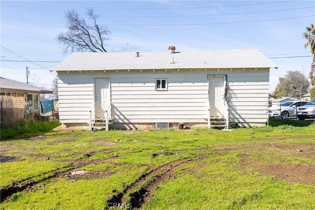 back of house with entry steps and a lawn