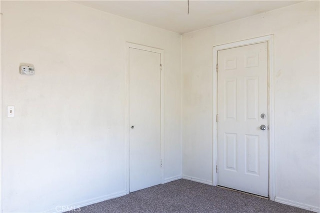 unfurnished bedroom featuring carpet floors, a closet, and baseboards