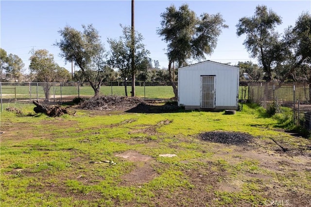 view of yard with a storage shed, an outdoor structure, and fence