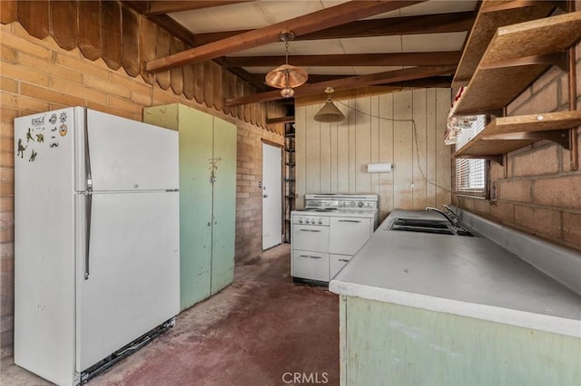 kitchen with decorative light fixtures, light countertops, stove, freestanding refrigerator, and a sink