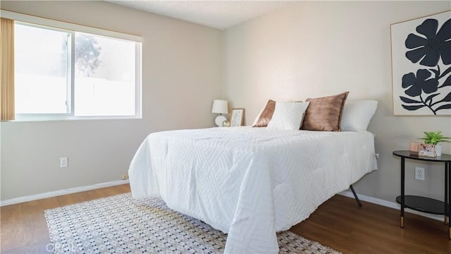 bedroom with wood finished floors and baseboards