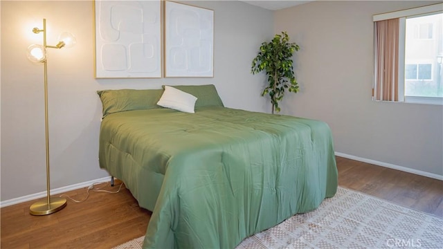 bedroom featuring baseboards and wood finished floors