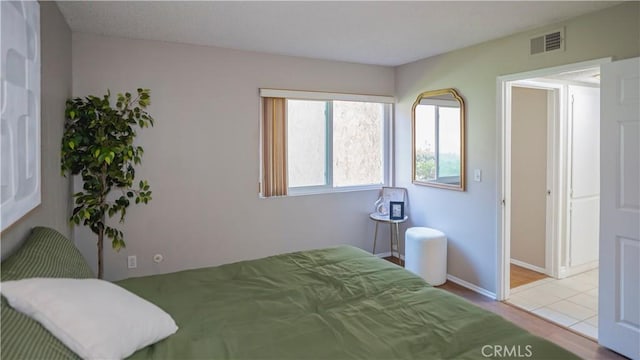 tiled bedroom with baseboards and visible vents