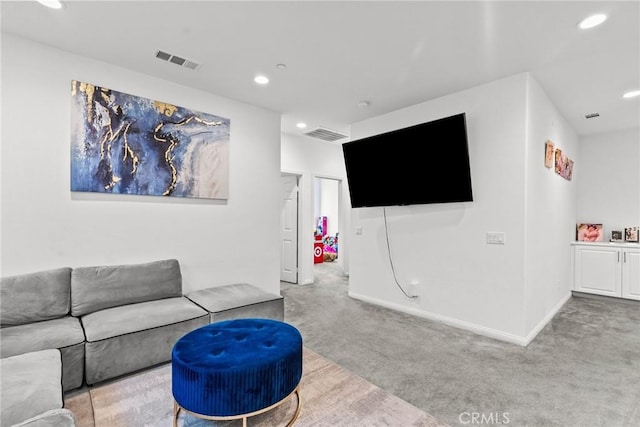 living area with light carpet, visible vents, and recessed lighting