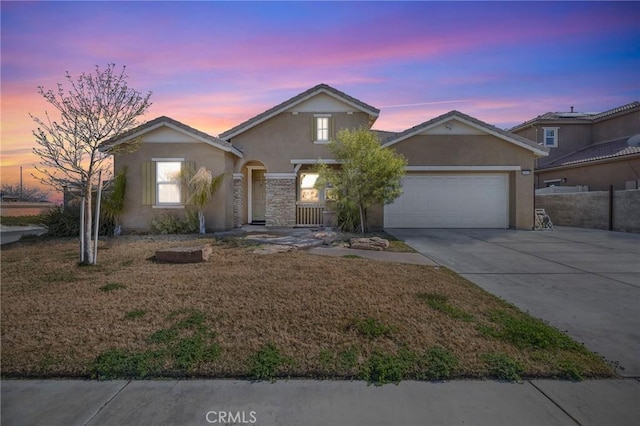 view of front of property with a garage, concrete driveway, a yard, and stucco siding