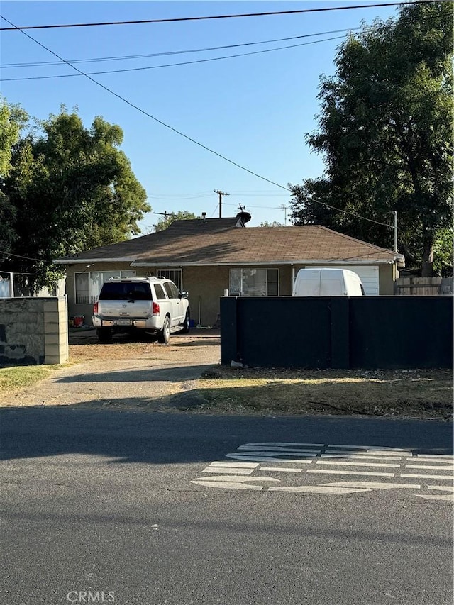 view of front of property featuring fence and a carport