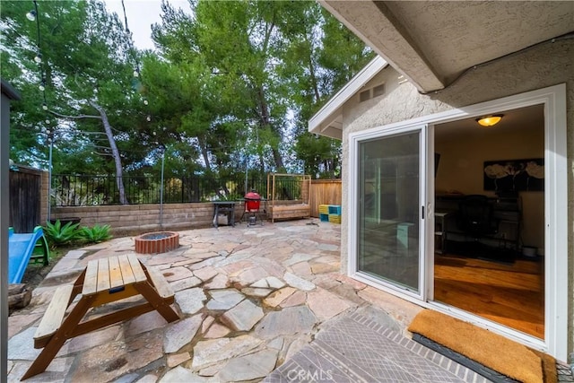 view of patio featuring a fenced backyard, visible vents, and a fire pit