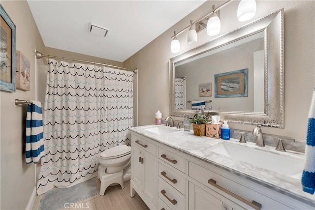 bathroom with toilet, curtained shower, double vanity, and a sink