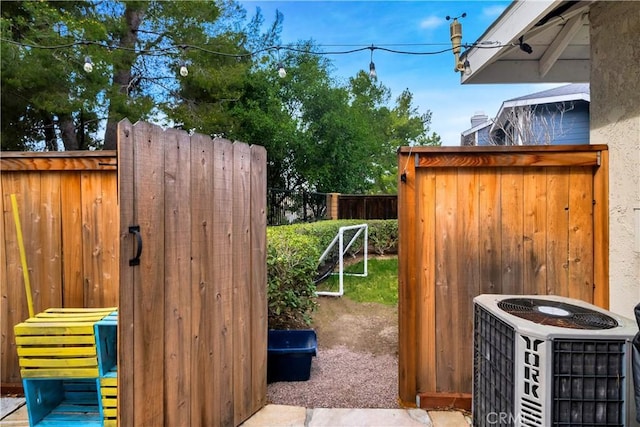 view of gate with fence and cooling unit