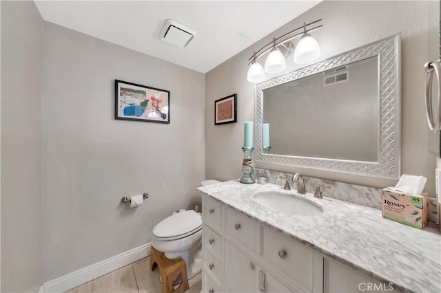 bathroom featuring toilet, visible vents, baseboards, and vanity