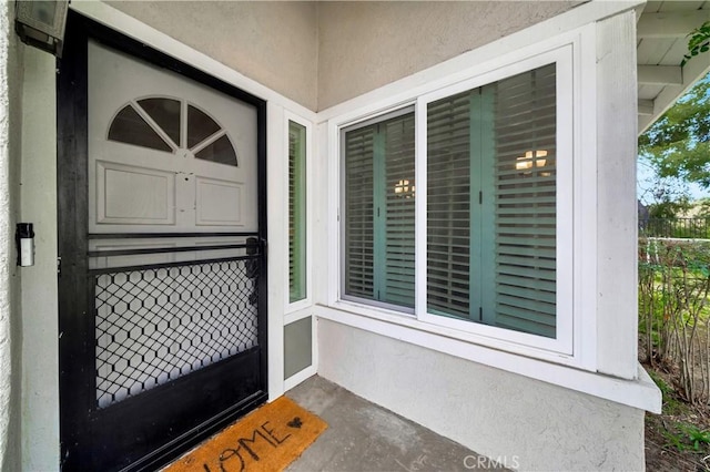 property entrance with stucco siding