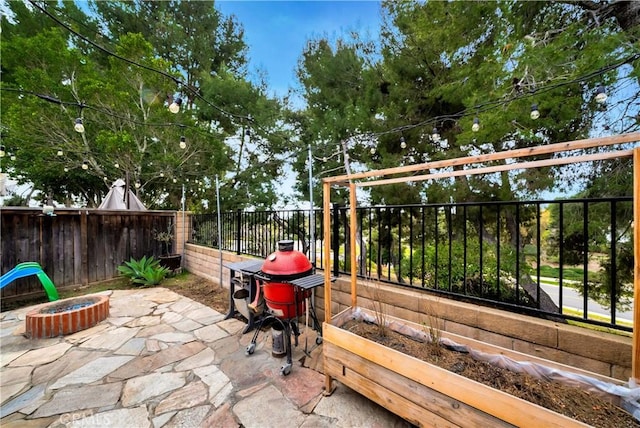 view of patio / terrace with fence and a fire pit