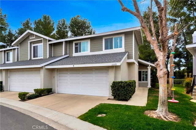 multi unit property with a garage, concrete driveway, roof with shingles, and stucco siding