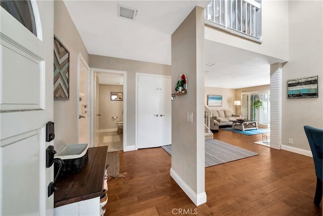 foyer entrance featuring visible vents, hardwood / wood-style flooring, and baseboards