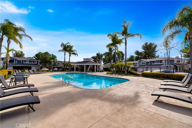 pool featuring a patio area, a residential view, fence, and a gazebo