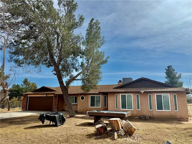 ranch-style house with a garage, driveway, and stucco siding