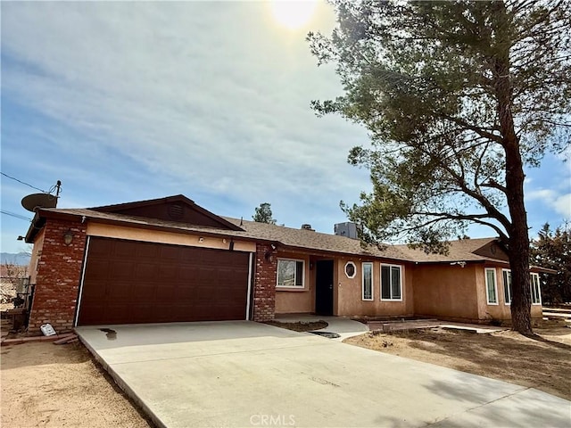 single story home with an attached garage, driveway, and brick siding