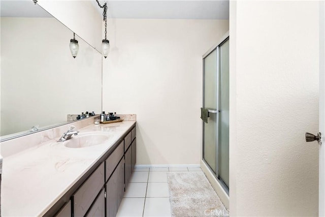 full bathroom featuring a stall shower, tile patterned flooring, vanity, and baseboards