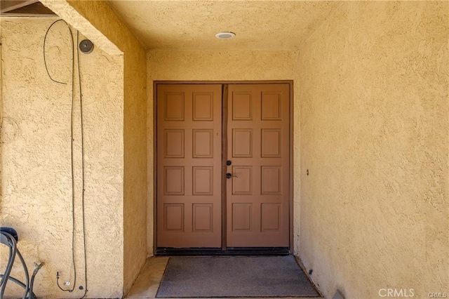 view of exterior entry with stucco siding