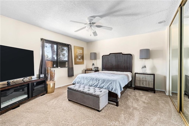 bedroom featuring a textured ceiling, carpet floors, a ceiling fan, and baseboards