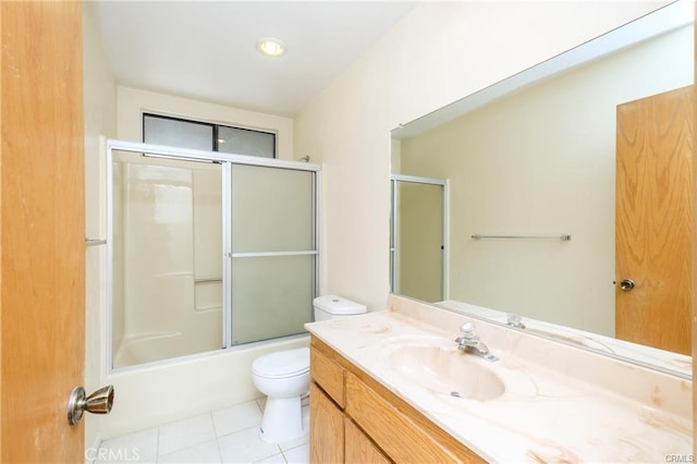 bathroom with toilet, tile patterned flooring, combined bath / shower with glass door, and vanity