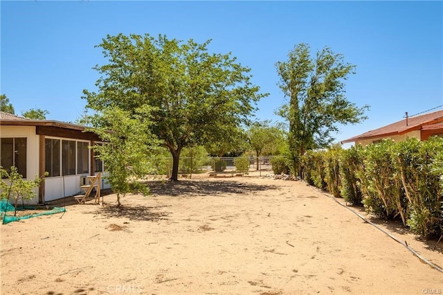 view of yard with a sunroom and fence