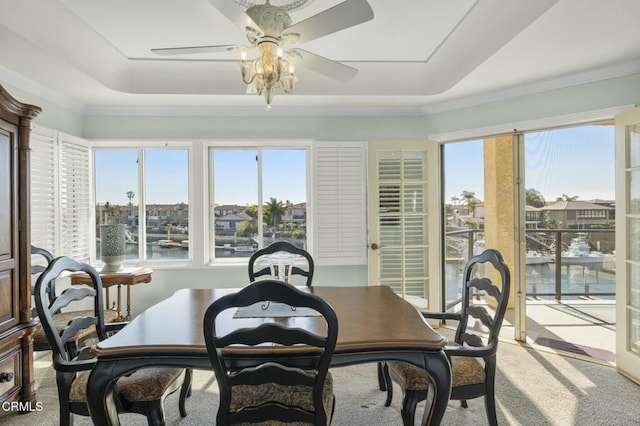 dining space with carpet floors, crown molding, and a ceiling fan