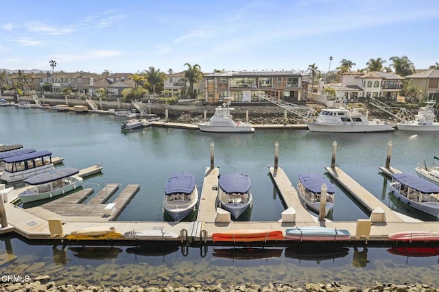 view of dock with a water view and a residential view